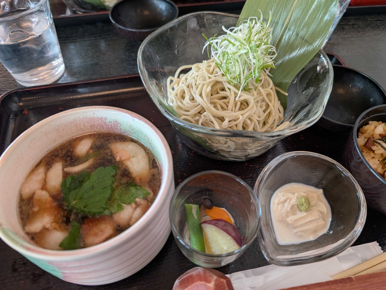 具だくさんの温かい鴨汁と緑がかった新蕎麦のアップ