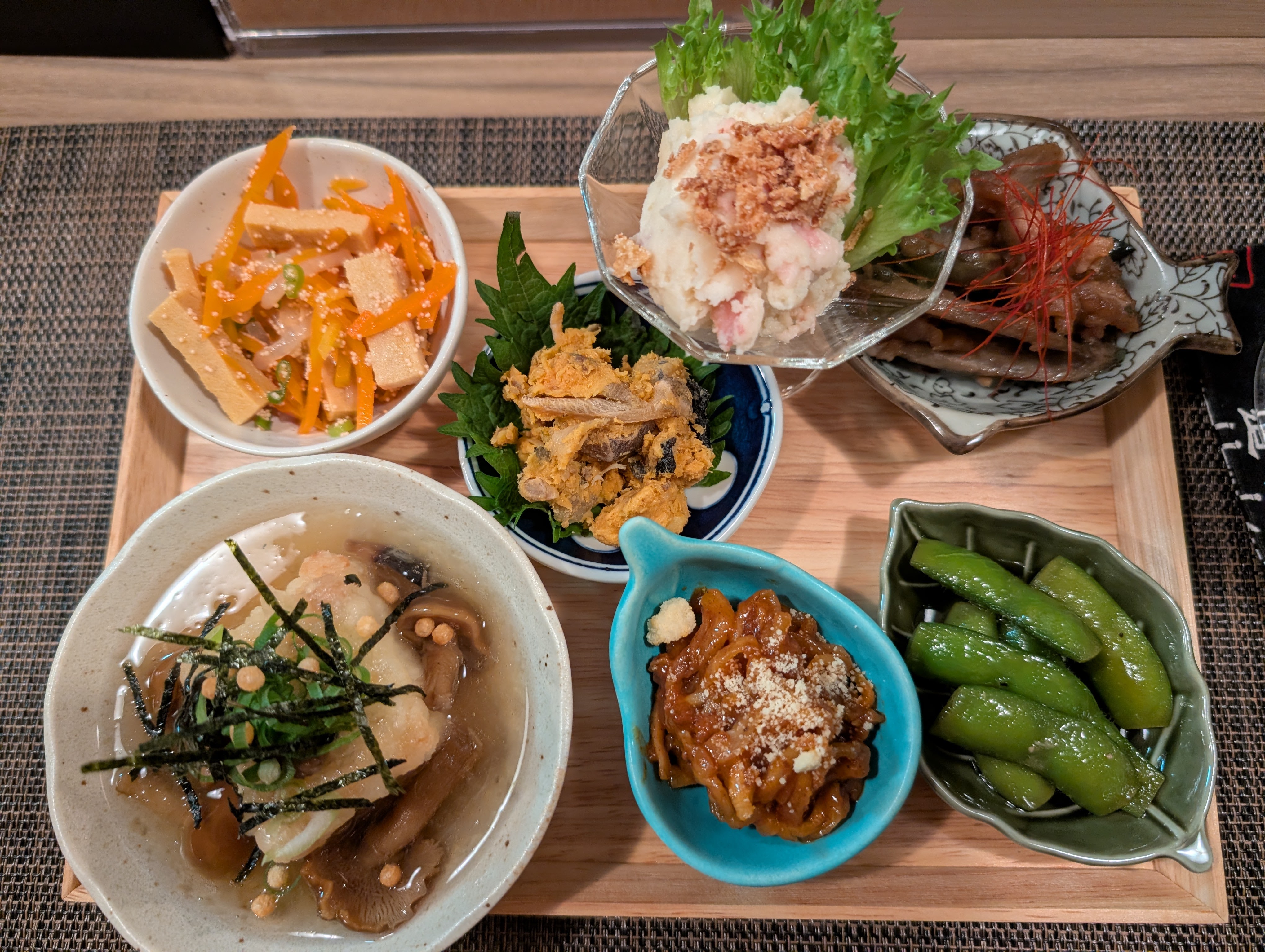 昭和レトロな隠れ家のおばんざい店のおばんざいセット。色とりどりの小鉢が並ぶ家庭料理