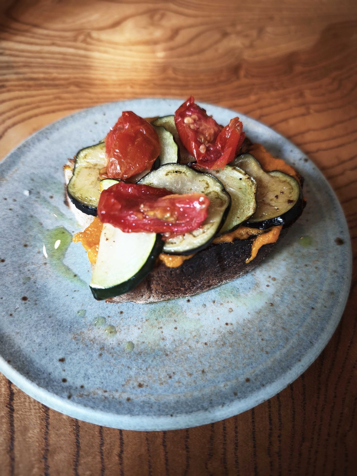 香ばしくローストされた野菜と鮮やかな人参ペーストが乗ったオープンサンド