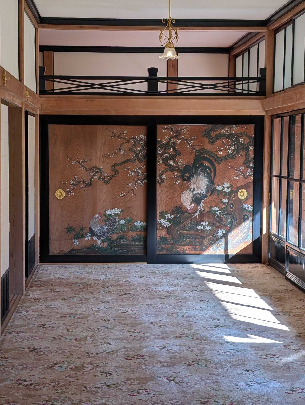 杉戸に鶏と梅が描かれた部屋。天井は洋風のシャンデリア