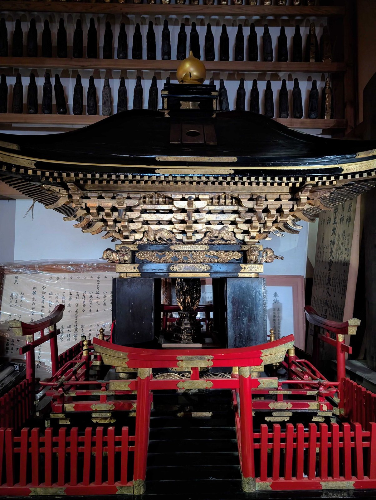 大仏の横に置かれた神輿。黒漆に金、赤い高欄