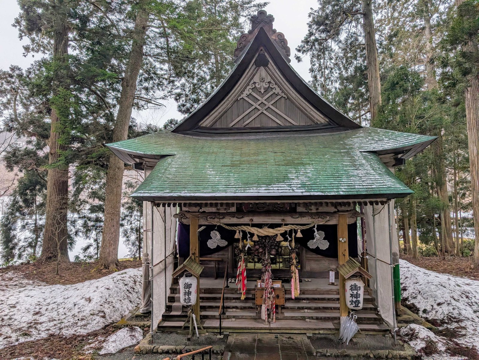 階段を下りた先にある社殿。緑青の屋根に雪が残る